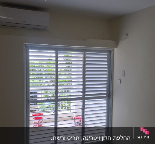 תריסי אלומיניום לבנים על חלון זכוכית